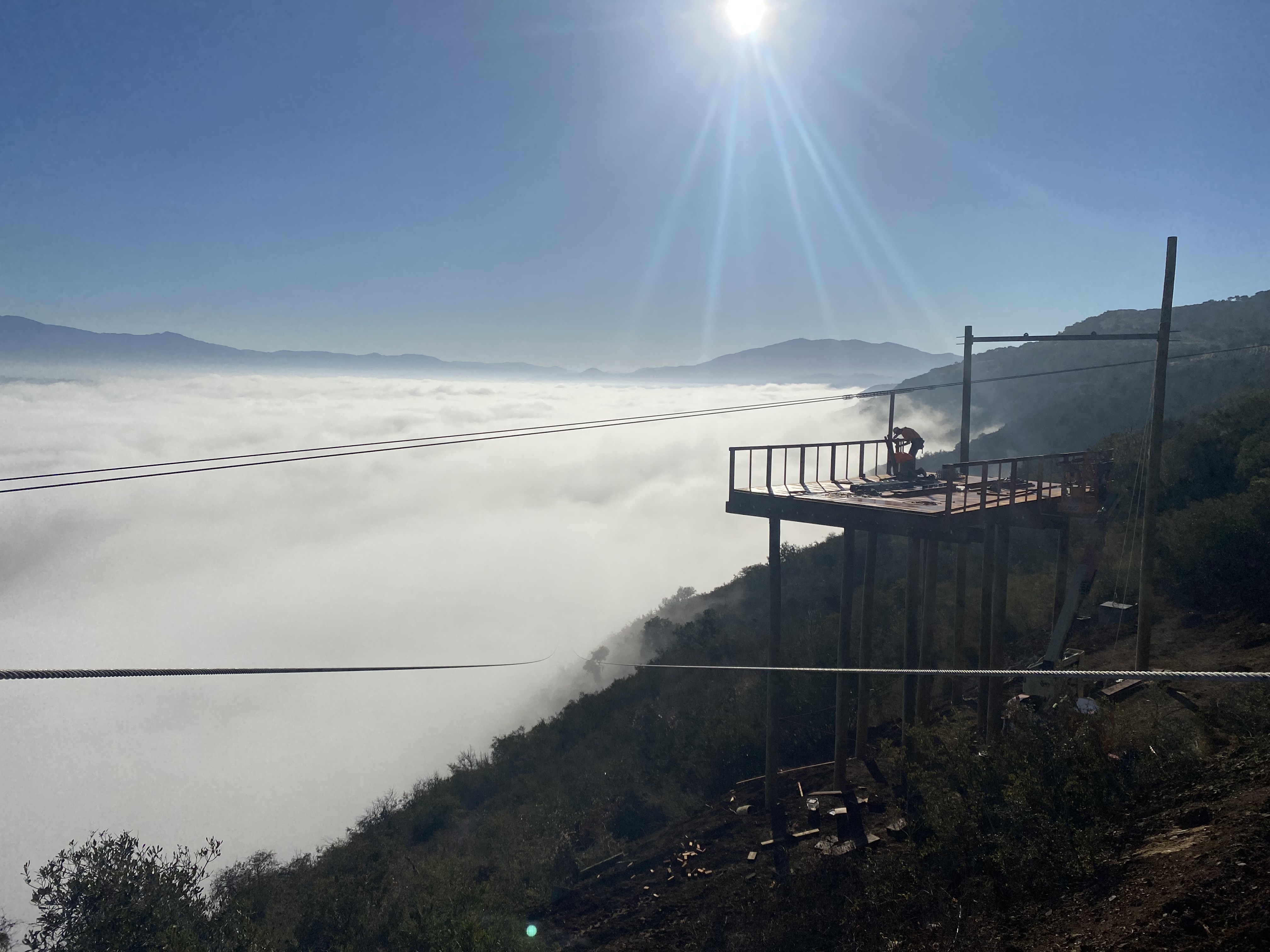 A rider flying back down the zipline after hiking to the summit at Highline Adventures.